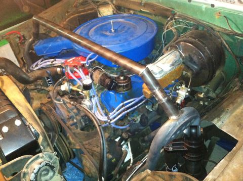 1977 Ford F-350 - The engine bay shows a V8 engine with a custom exhaust pipe modification.