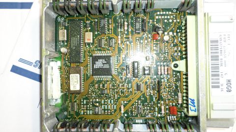 1994 Ford Bronco - Close-up of an engine control unit's internal circuitry, showing complex electronic components and wiring.