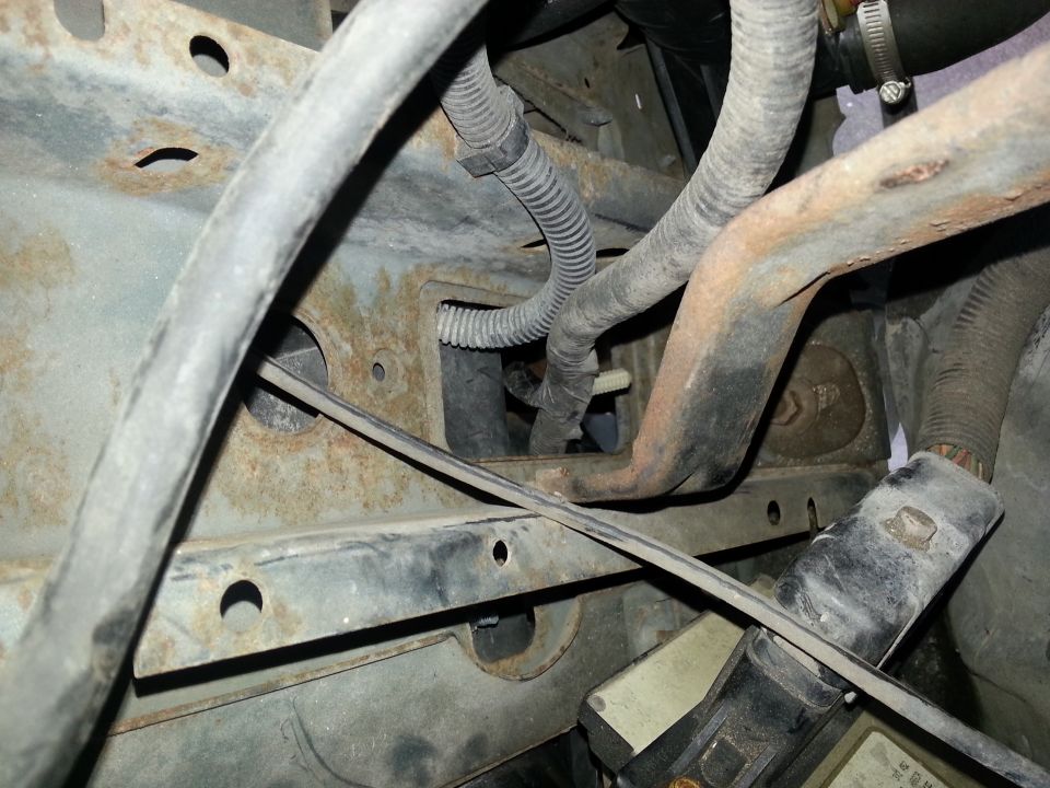 Engine bay hoses and rusty metal frame