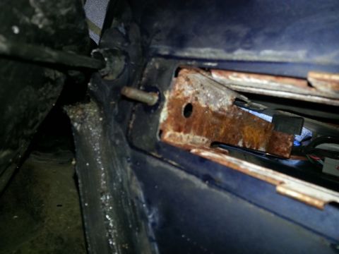 1994 Ford Bronco - Close-up of a rusted metal bracket and wiring, likely from a vehicle's undercarriage.