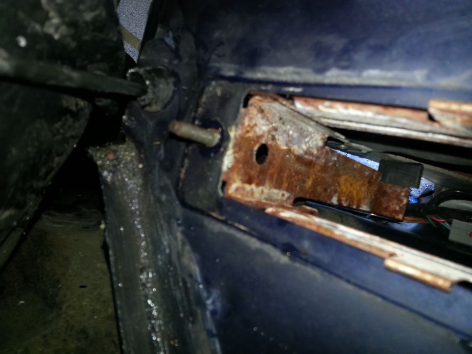 rusted metal bracket with bolt and wiring visible