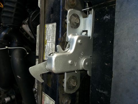 1994 Ford Bronco - Hood latch mechanism shown in detail, with some visible hoses and a warning label.