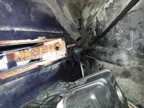 1994 Ford Bronco - This image shows a close-up view of a vehicle's inner fender well and a corroded mounting bracket.
