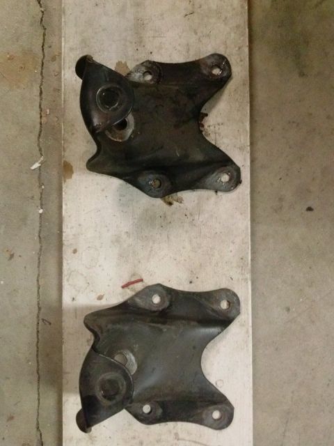 1995 Ford Bronco - Two metal brackets are shown on a wooden board, possibly for automotive repair or replacement.