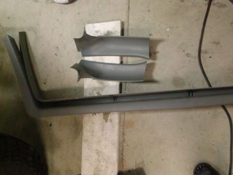 1995 Ford Bronco - Several car door trim pieces are laid out on a concrete floor, possibly for repair or replacement.