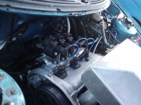 1995 Ford Probe - Close-up view of an engine bay, blue spark plug wires and a metallic intake component.