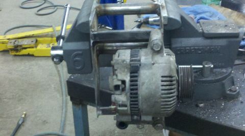 1989 Ford F-150 - An automotive alternator is secured in a vise, ready for work or inspection.