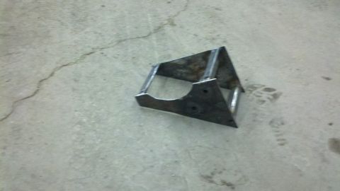 1989 Ford F-150 - A fabricated metal bracket sits on a cracked concrete surface.