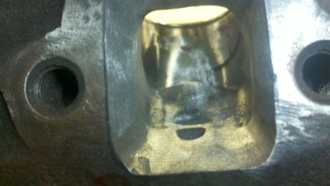 1989 Ford F-150 - A close-up view of an engine cylinder head port, showing internal casting details and threaded holes.