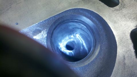 1989 Ford F-150 - A close-up view of a cylinder head intake port, showing the machined surfaces and the central opening.