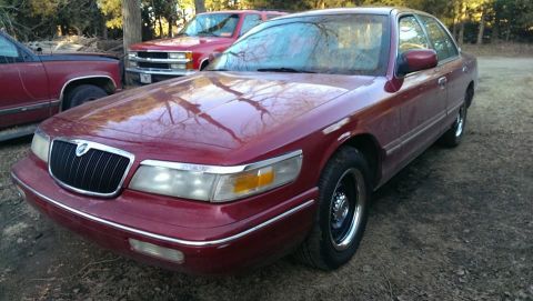 2000 Mercury Grand Marquis - Maroon 2000 Mercury Grand Marquis sedan parked outdoors with other vehicles.