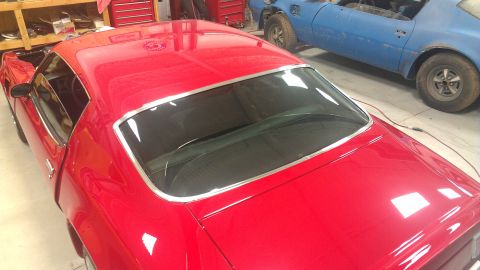 1972 Pontiac Trans Am - A red coupe is parked next to a blue car in a garage.