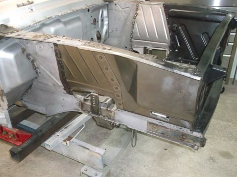 1967 Ford Mustang - Close-up view of a car's chassis undergoing repair work, highlighting welded sections and structural elements.