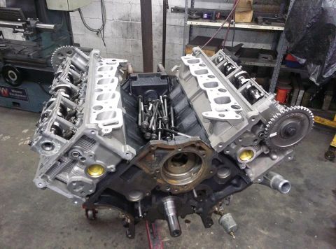 2004 Ford Crown Victoria - A disassembled V8 engine is shown in a workshop setting, with parts laid out for repair or modification.
