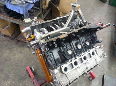 2004 Ford Crown Victoria - Engine block on a stand, with internal components visible, in a workshop setting.