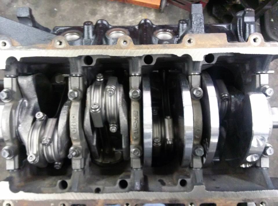 Inverted engine short block showing crankshaft, rods, and main bearing caps