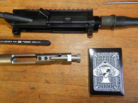 1996 Ford Bronco - AR-15 upper receiver and bolt carrier group laid out with a charging handle and deck of cards.