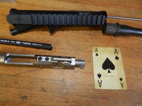 1996 Ford Bronco - Gun parts and playing cards are laid out on a wooden surface.