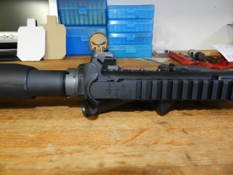 1996 Ford Bronco - Close-up of an AR-15 rifle receiver assembly, with tactical accessories and ammunition storage visible in the background.