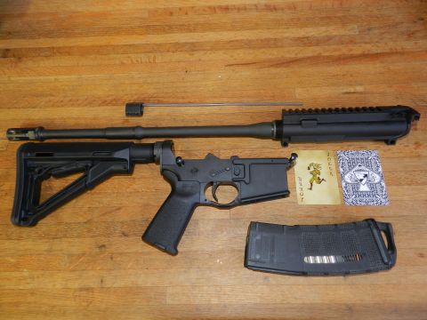 1996 Ford Bronco - Disassembled rifle parts, including the receiver, barrel, and magazine, are laid out on a wooden surface.