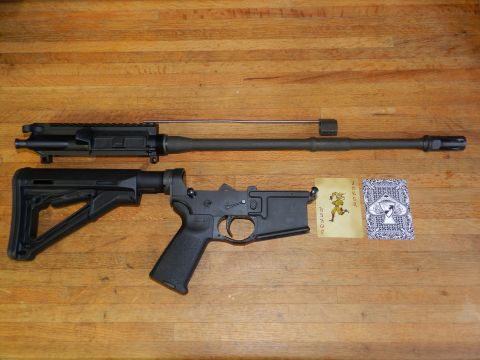 1996 Ford Bronco - Disassembled AR-15 rifle components laid out on a wooden surface next to playing cards.