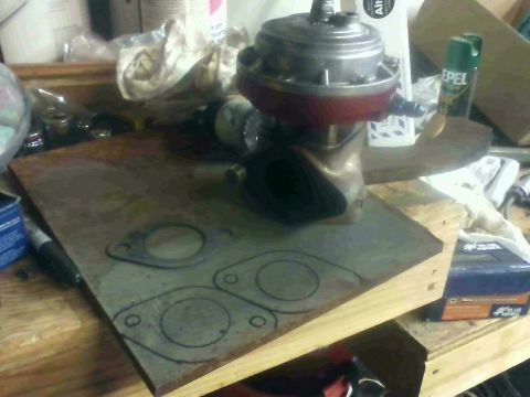 1995 Ford Probe - Turbo wastegate and exhaust gaskets on a workbench.