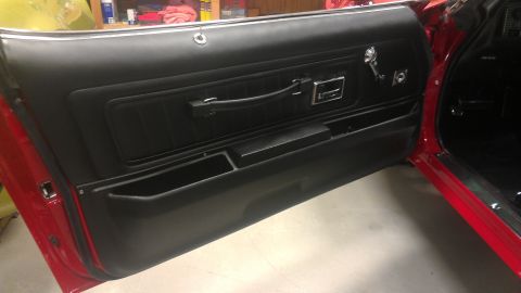 1972 Pontiac Trans Am - Interior view of a red car's black door panel with chrome accents and storage.