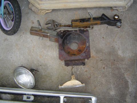 1986 Ford Bronco - Assorted vehicle parts and tools are displayed on a concrete surface.