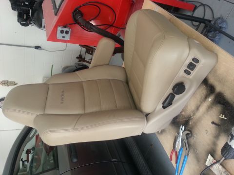 1994 Ford Bronco - A tan leather car seat, identified as Lariat trim, is shown with its power adjustment controls visible.