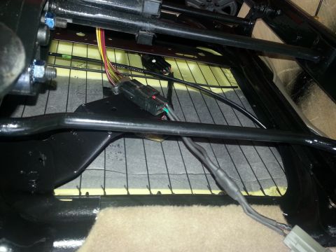 1994 Ford Bronco - Wiring harness and connectors are visible beneath the seat cushion of a vehicle.