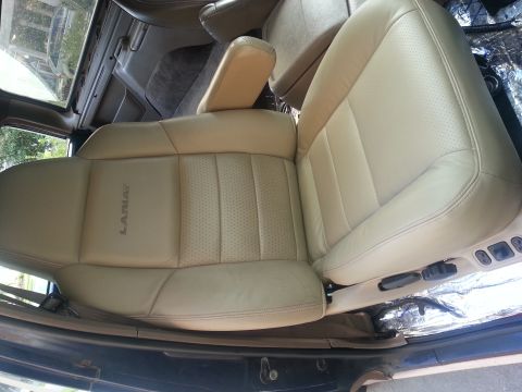 1994 Ford Bronco - Interior view of tan leather bucket seats with Lariat badging and perforated inserts.