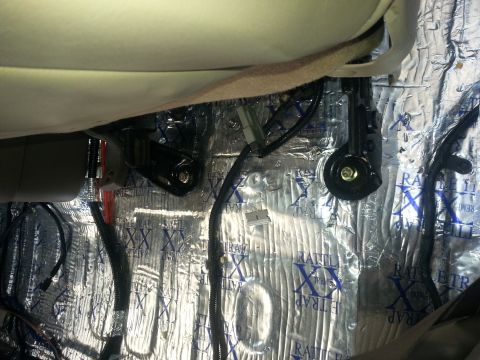 1994 Ford Bronco - Sound deadening material installed on the floor of a car interior, showing seat brackets and wiring.