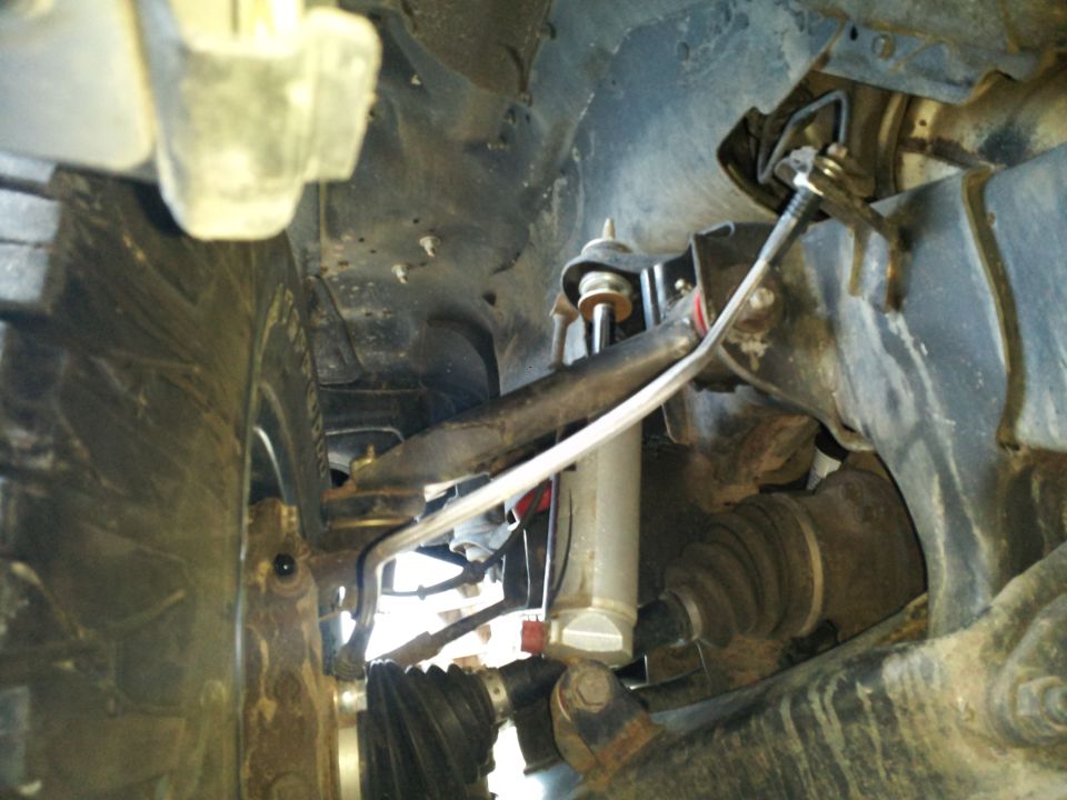 Close-up of truck's front suspension, tire, and CV axle