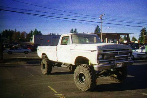 1976 Ford F-150 - This lifted 1976 Ford F-150 pickup truck is parked outdoors on pavement.