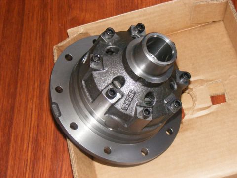 Differential carrier with bolts and a cylindrical opening, resting in a cardboard box