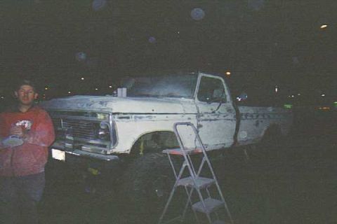 1976 Ford F-150 - A white Ford F-150 truck with a primer finish is viewed from the front 3/4 angle, with a ladder nearby.
