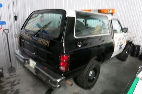 1991 Ford LTD Crown Victoria - A black and white police SUV is parked indoors, showing its rear and side profile.