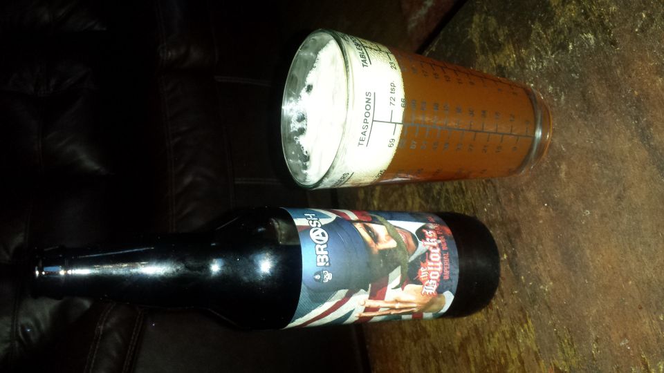 Beer bottle with Union Jack label and measuring cup with white powder on a dark surface