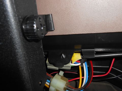 1992 Ford Bronco - A close-up view of the interior of a vehicle shows a complex wiring harness and a black rotary knob.