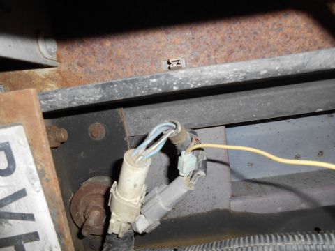 1992 Ford Bronco - Close-up of a wiring harness and rusted metal frame, likely from a vehicle's undercarriage.