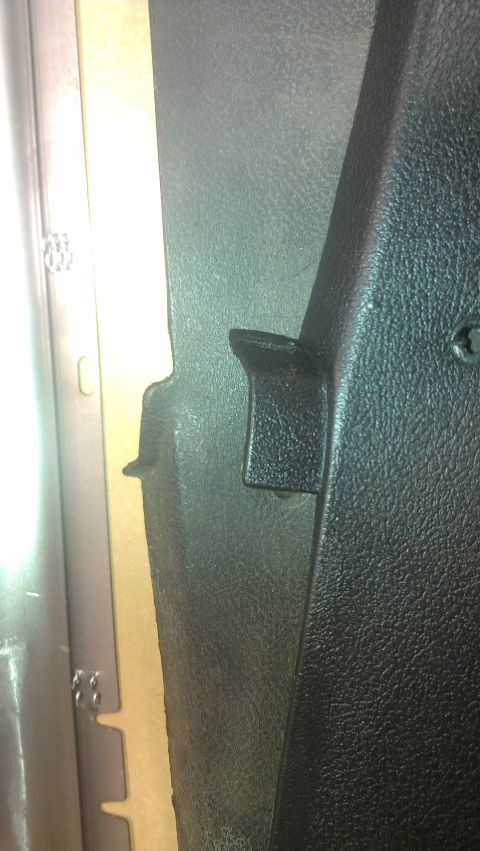 1973 Chevrolet Camaro - Close-up of a black textured plastic interior trim panel with a metal bracket.