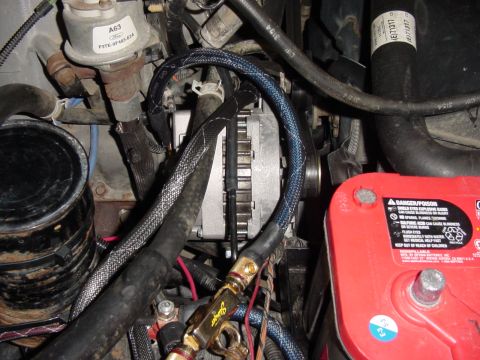 1995 Ford Bronco - Close-up view of the engine bay, focusing on the alternator and battery components.