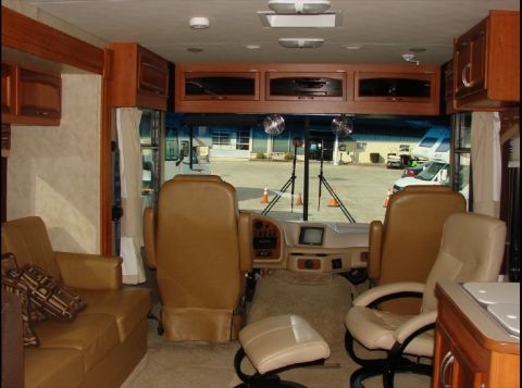 2010 Ford F-450 - Interior view of a recreational vehicle showing the driver and passenger seats, couch, and cabinetry.