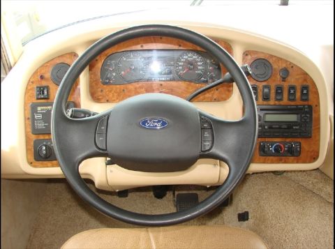 2010 Ford F-450 - The interior of an RV shows the dashboard, steering wheel, and center console with various controls and a radio.
