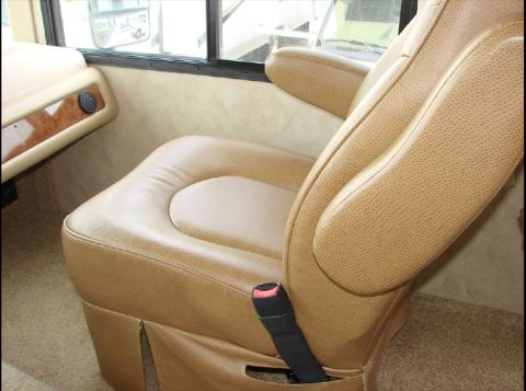 2010 Ford F-450 - Interior view of a tan leather driver's seat, showing the seatbelt and armrests.