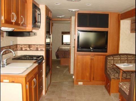 2010 Ford F-450 - The interior of a recreational vehicle features a kitchen, entertainment center, and sleeping area.
