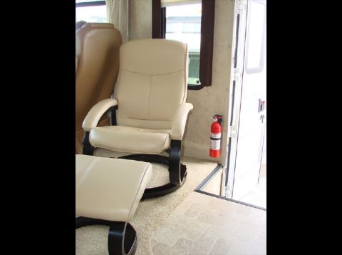 2010 Ford F-450 - The interior of a vehicle features a comfortable recliner chair and ottoman, with a fire extinguisher readily accessible on the wall.