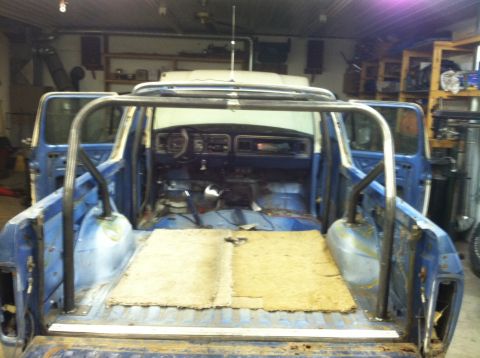 1979 Ford Bronco - The interior of a 1979 Ford Bronco is visible, a roll cage and blue exterior paint.
