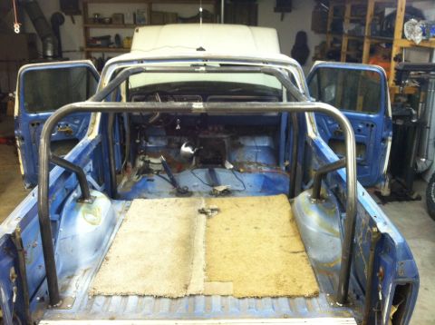 1979 Ford Bronco - Custom roll cage installed in the interior of a blue pickup truck during a build.