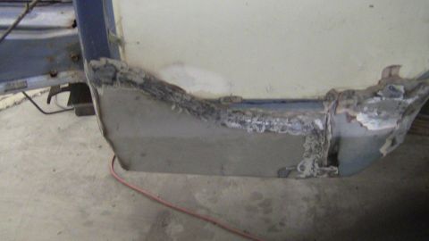 1979 Ford Bronco - Close-up of a heavily rusted and damaged vehicle body panel undergoing repair.